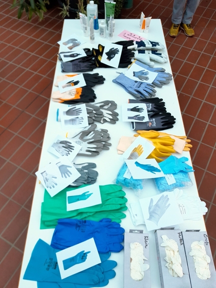 Vergrößerung des Bildes für Ein Tisch mit einer Auswahl verschiedener Handschuhe und Hautcremes..
